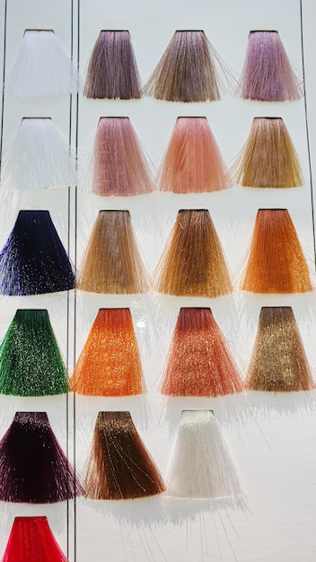 Eine Palette von Haarfarben aus künstlichen Strängen auf weißem Hintergrund Farbwahl Kopierraum