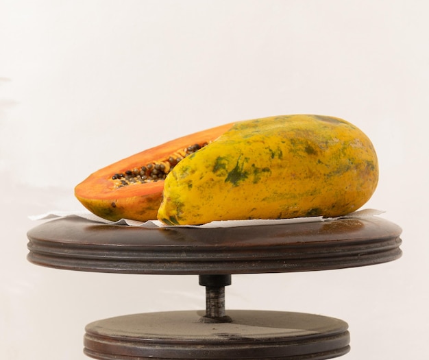 Eine Papaya auf einem Ständer mit weißem Hintergrund