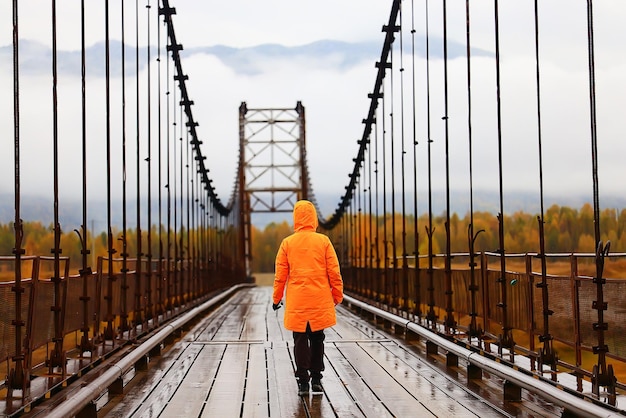 eine person auf der brücke von hinten, reiseabenteuer, hängebrücke