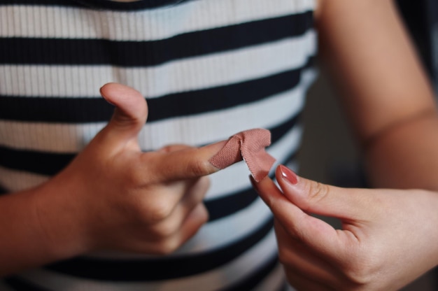 Eine Person, die ein gestreiftes Hemd trägt und einen gebrochenen Finger hat