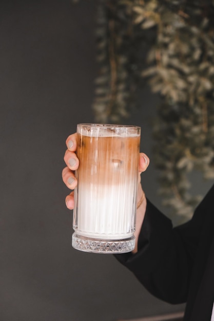 eine Person, die ein Glas Bier mit dem Wort Drink hält