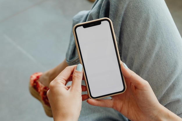 eine Person, die ein Telefon mit einem leeren Bildschirm hält
