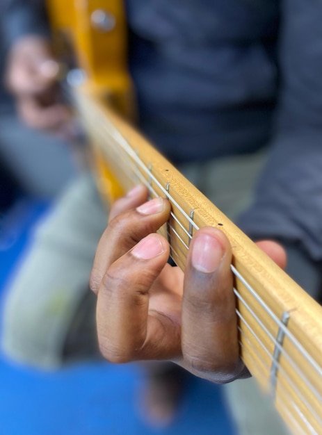 Eine Person, die eine Gitarre mit den Fingern auf den Saiten spielt