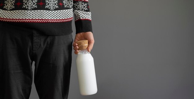 Eine person, die eine glasflasche mit veganer milch hält