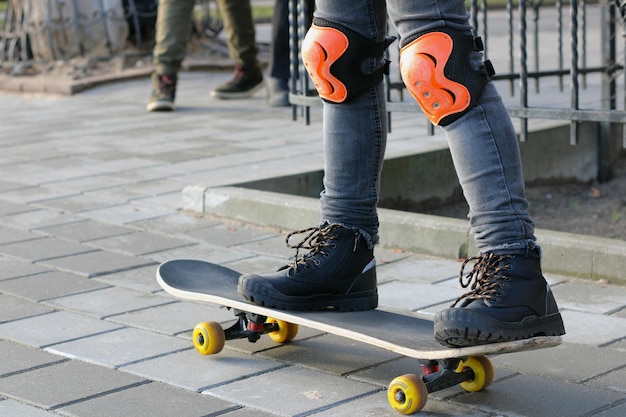 Eine Person, die Knieschützer und ein Paar Knieschützer auf einem Skateboard trägt