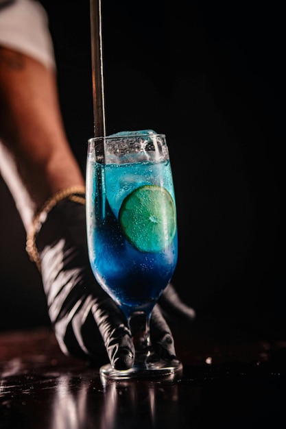 eine Person hält ein Glas mit einem Getränk und einer Limette