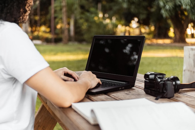 Eine Person mit einem Laptop in einem Park