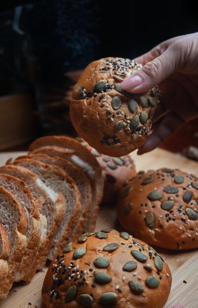 Eine Person nimmt ein Stück Brot von einem Tisch.