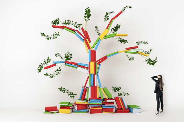 Eine Person schaut auf einen bunten Baum aus Büchern mit grünen Blättern, die Wissen auf einem Licht symbolisieren