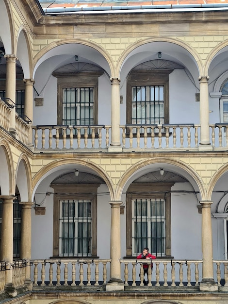 Eine Person sitzt auf einer Bank vor einem Gebäude, auf dem „Opera“ steht