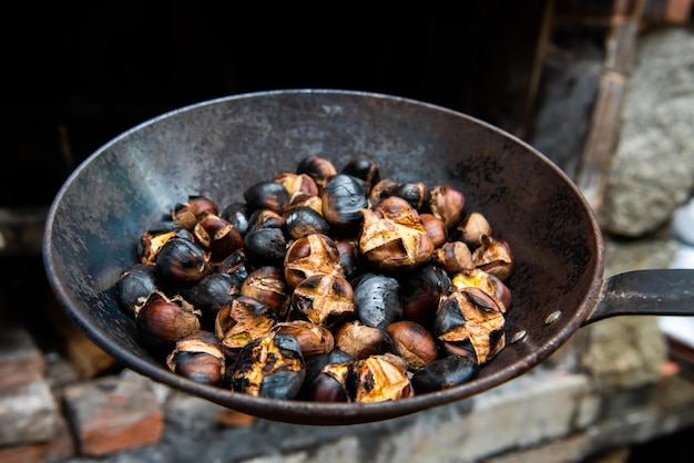 Eine Pfanne mit Bio-Kastanien gegrillt auf dem Grill