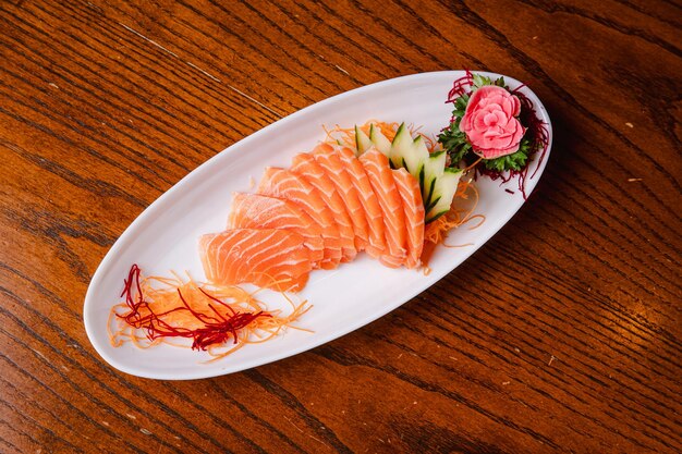 eine Platte Lachs mit einer Blume darauf