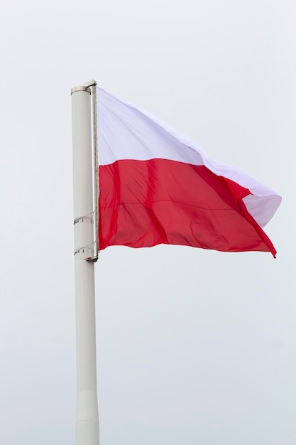 Eine polnische Flagge weht an einem Mast am Himmel