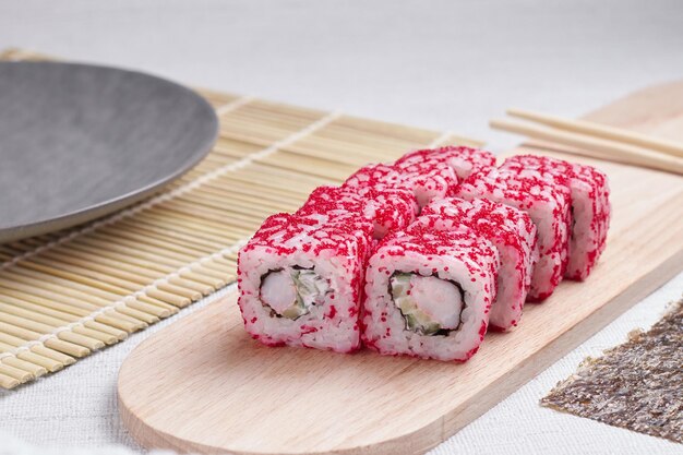 Eine Portion Brötchen auf einem Ständer, japanisches Essen, Sushi auf dem Tisch, chinesische Essstäbchen, heller Hintergrund