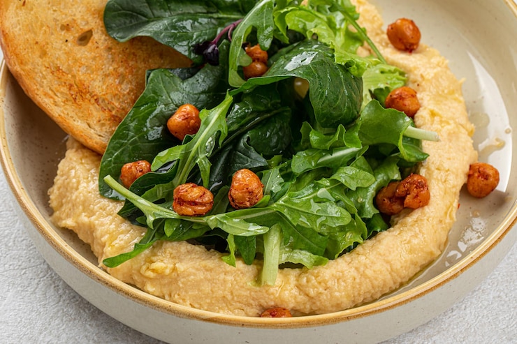 Foto eine portion hummus mit grünen und toast
