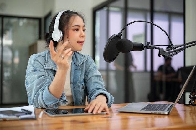 Eine professionelle asiatische Radiomoderatorin oder Podcaster spricht in ein Mikrofon und kündigt Nachrichten an