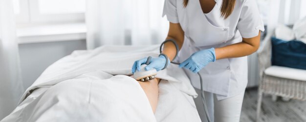 Eine professionelle Masseurin, die eine Endermologie-LPG-Massage für eine Kundenkosmetikklinik durchführt