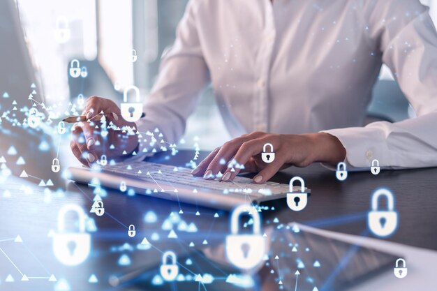 Eine Programmiererin gibt einen Code auf dem Computer ein, um eine Cyber-Sicherheit vor Hackerangriffen zu schützen und vertrauliche Daten der Kunden zu speichern Vorhängeschloss-Hologramm-Symbole über den Schreibhänden Formelle Kleidung