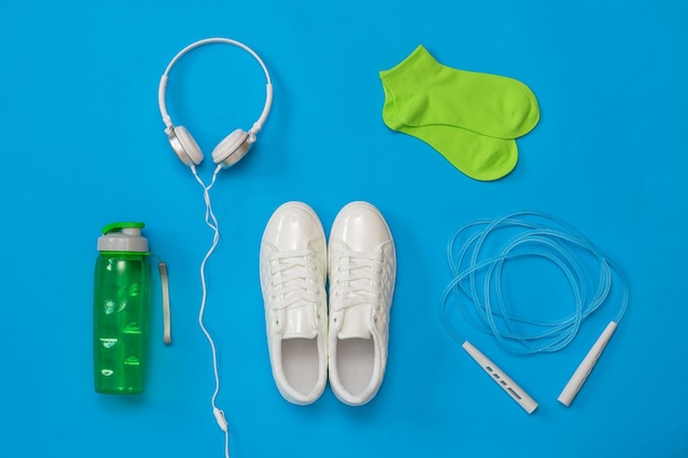 Eine Reihe von Fitness-Accessoires auf blauem Hintergrund. Das Konzept des sportlichen Lebensstils.