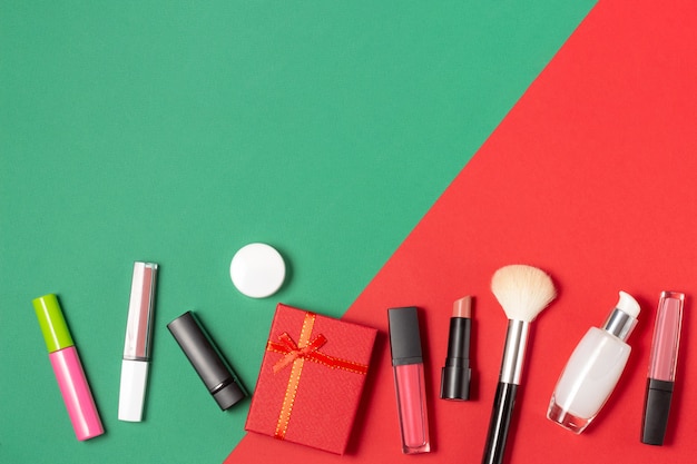 Eine Reihe von Gesichtskosmetik und eine Geschenkbox auf rotem und grünem Hintergrund.