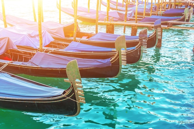 Eine Reihe von Gondeln am Pier im Wasserbootparkplatz Venedig-Postkarten-Konzept