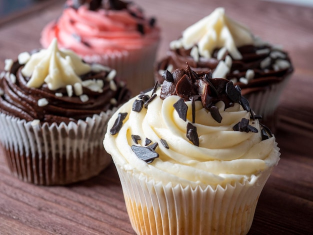 Eine Reihe von köstlichen und süßen Schokoladen-Cupcakes auf einem hölzernen Hintergrund Hochkalorischer Dessert selektiver Fokus