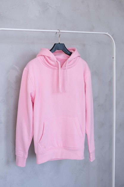 Eine Reihe von Layouts eines rosa Hoodies mit Kapuze und einer Tasche, die an einem Kleiderbügel hängt