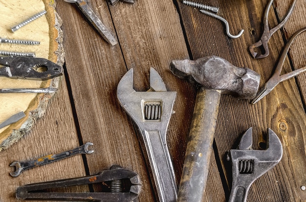 Eine Reihe von Metallwerkzeugen in der Werkstatt auf rustikalem HolzhintergrundVatertag oder Arbeitstag