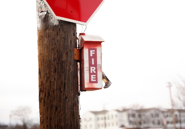 Eine rote Feuerbox steht auf einer Stange neben einem Stoppschild.