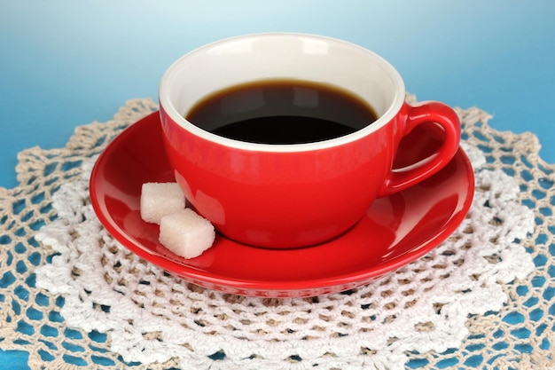 Eine rote Tasse starken Kaffee auf blauem Hintergrund