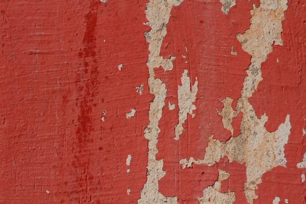 Eine rote Wand mit abblätternder Farbe und einem weißen Hintergrund.
