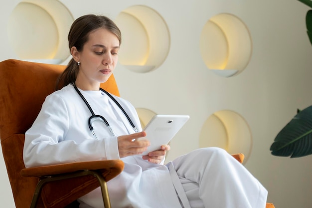 Eine Ärztin arbeitet im Büro einer modernen Klinik, ein Arzt mit einem Tablet-Computer, ein Arzt in einer