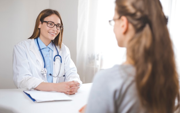 Eine Ärztin berät die Patientin im Büro der Klinik.