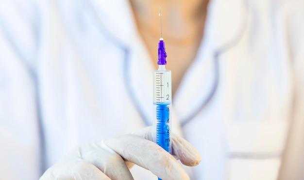 Eine Ärztin hält eine Spritze vor sich, die mit Arzneimitteln zur Injektion gefüllt ist Konzentrieren Sie sich auf die Spritze
