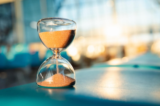 Eine Sanduhr sitzt auf einem Stuhl im Flughafen Business-Rush-Hour-Konzept