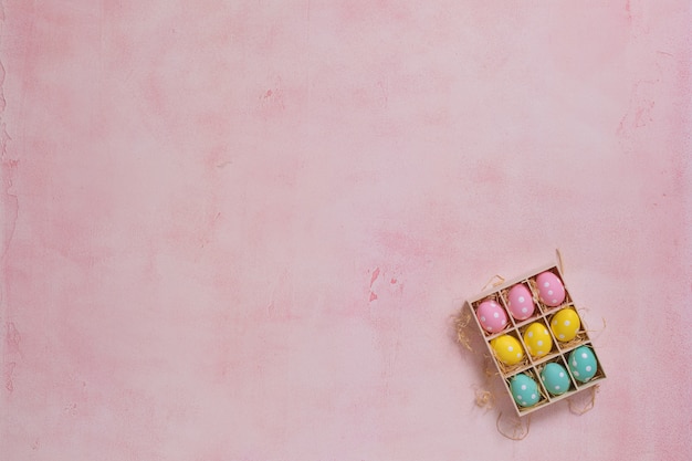 Foto eine schachtel mit bunten ostereiern auf rosa hintergrund