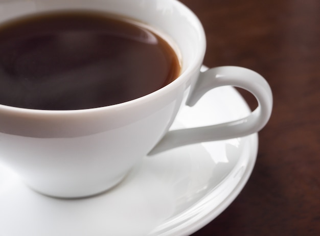 Eine Schale heißer americano Kaffee oder heißer Espressokaffee auf Holztisch.