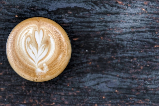 Eine Schale heißer Lattekunstkaffee auf Tabelle