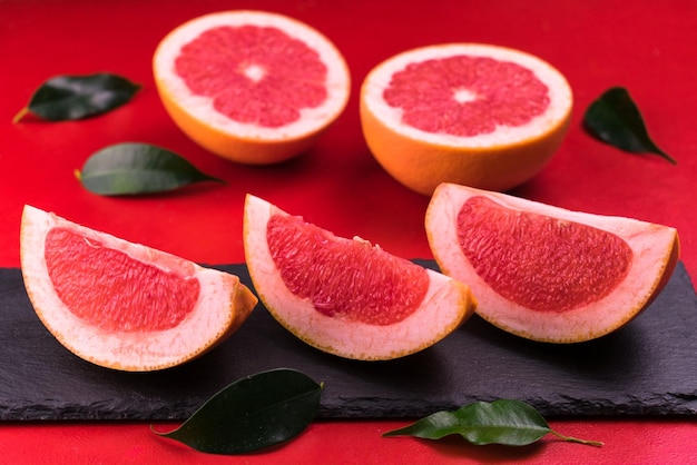 Eine Scheibe Grapefruit sitzt auf einem schwarzen Stein.