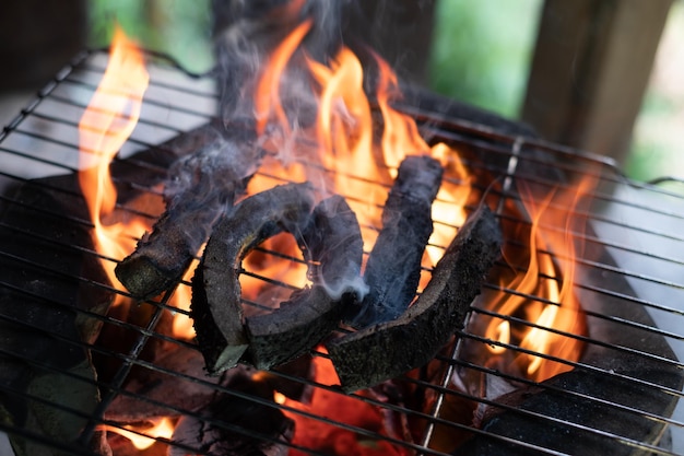 Eine Scheibe Rindsleder über einem offenen Holzkohlefeuer grillen