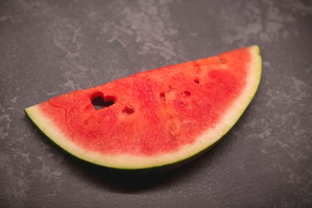 Eine Scheibe Wassermelone mit einem herzförmigen Loch