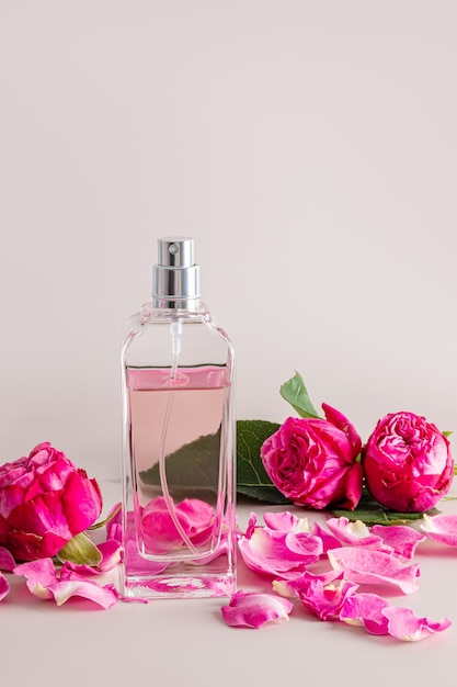 Eine schicke Flasche mit Damenparfüm und zarten Blütenblättern Tee Rose mit einem Rosenknospen Vordere vertikale Ansicht Unbenannte Flasche zur Produkteinführung