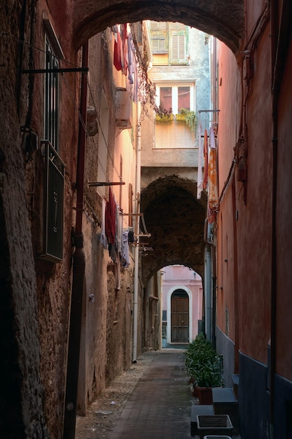 Foto eine schmale straße mit bunten gebäuden und zum trocknen aufgehängter wäsche in einer altstadt in europa, ventimigli