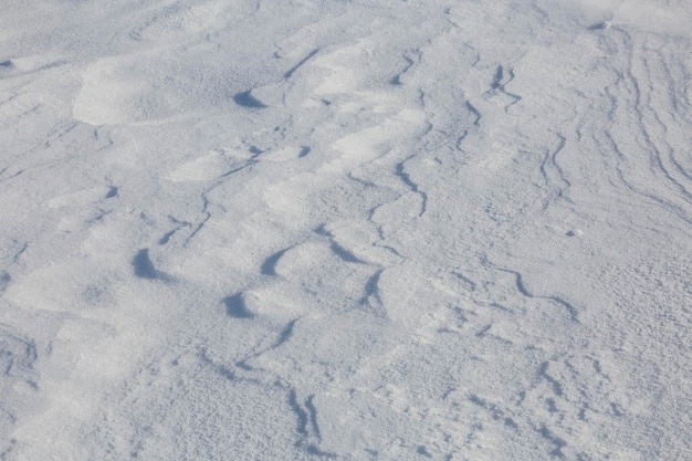 Eine Schneedecke wird vom Wind verweht