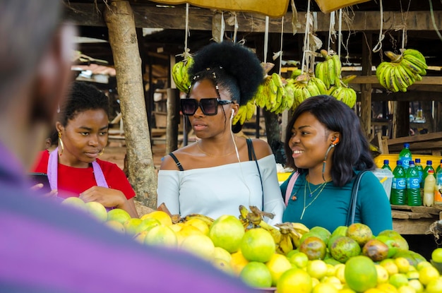 Eine schöne afrikanische Marktfrau und ihre Kunden sind aufgeregt, wenn sie diskutieren