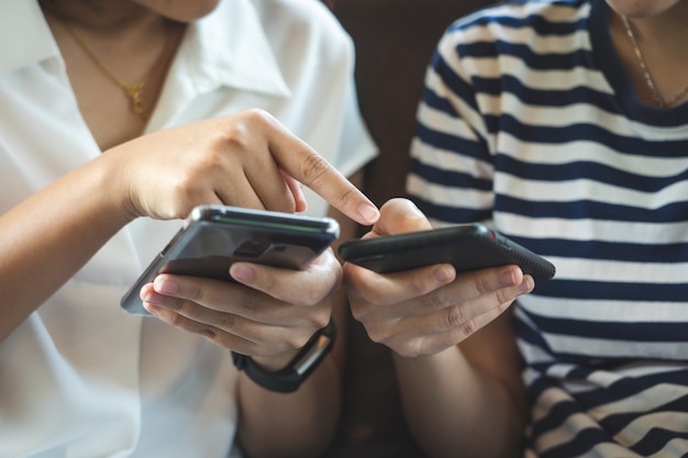 Eine schöne asiatische Frau benutzt ein smartphone im Stadtzentrum, um nach verschiedenem zu suchen