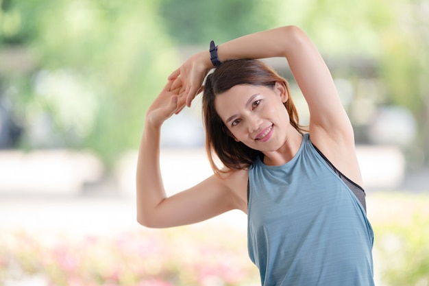 Eine schöne asiatische Frau in Sportoutfits, die sich vor dem Training zu Hause dehnt