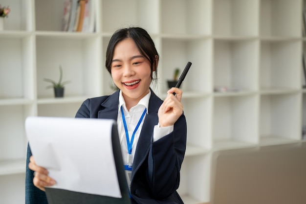 Eine schöne asiatische Geschäftsfrau untersucht einen Geschäftsbericht in ihrem Büro.