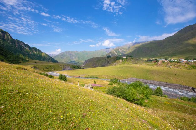 Eine schöne Berglandschaft mit einem kleinen gewundenen Fluss und einem blauen Himmel Mountainous Georgia