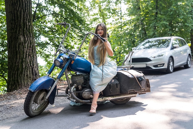 Eine schöne blonde Frau, die auf einem Motorrad sitzt